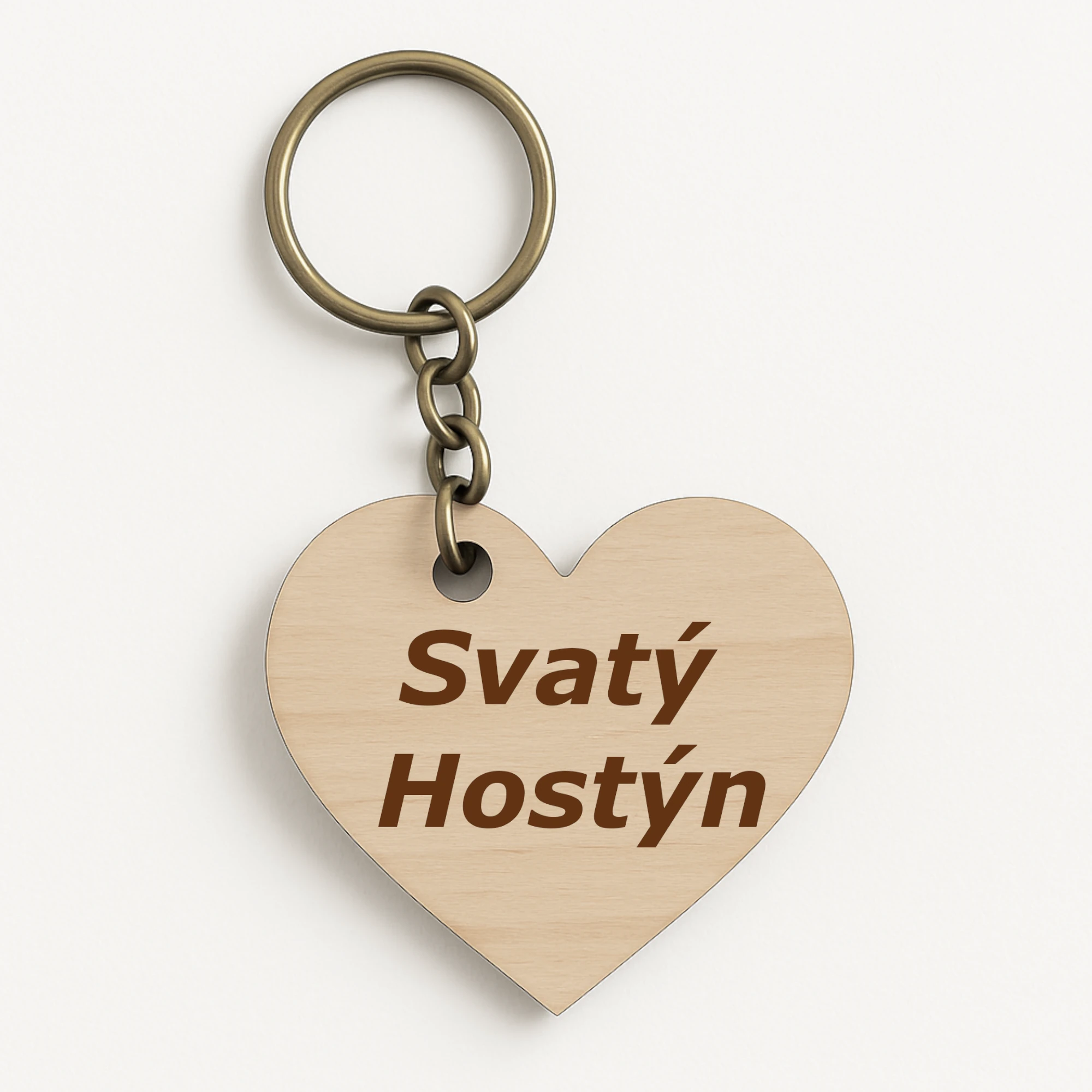 Dřevěná klíčenka ve tvaru srdce s nápisem „Svatý Hostýn“, vyrobená z bukové překližky, symbolická připomínka mariánského poutního místa.