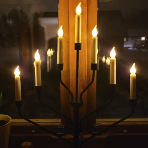 Sedmiramenný elektrický adventní svícen rozsvícený za oknem