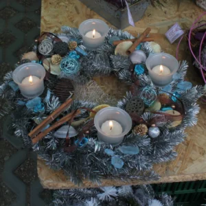 Adventní věnec se čtyřmi hořícími svícemi, šiškami a skořicí