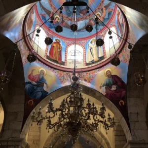Malovaná chrámová kupole s biblickými postavami nad mohutným lustrem