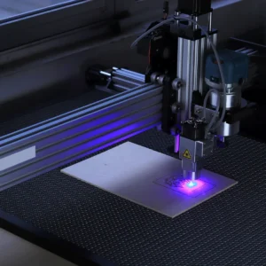 Detail laserové hlavy CNC stroje při práci nad materiálem