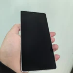 Ruka držící moderní telefon s vypnutou černou obrazovkou