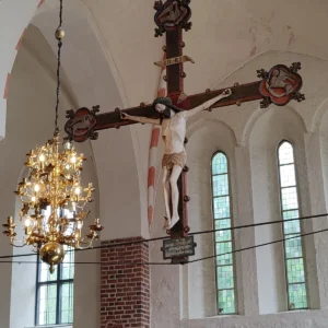Velký triumfální krucifix zavěšený pod klenbou kostela
