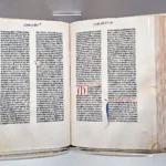 Otevřená historická Bible s hustými sloupci tištěného textu