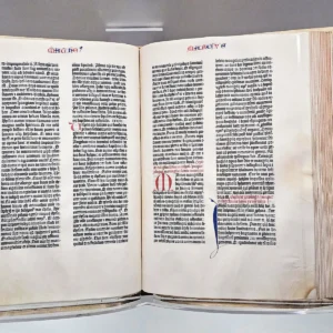 Otevřená historická Bible s hustými sloupci tištěného textu