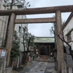Kamenná brána před japonskou svatyní v úzké městské ulici