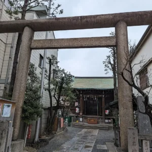 Kamenná brána před japonskou svatyní v úzké městské ulici