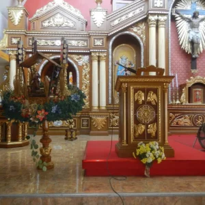 Kostelní interiér s adventním věncem, jesličkami a dřevěným ambonem