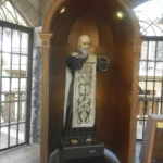 Socha otce Pia v řeholním rouchu ve výklenku