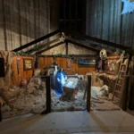 Jesličky s osvětleným dítětem, figurami a dřevěnou stájí v katedrále